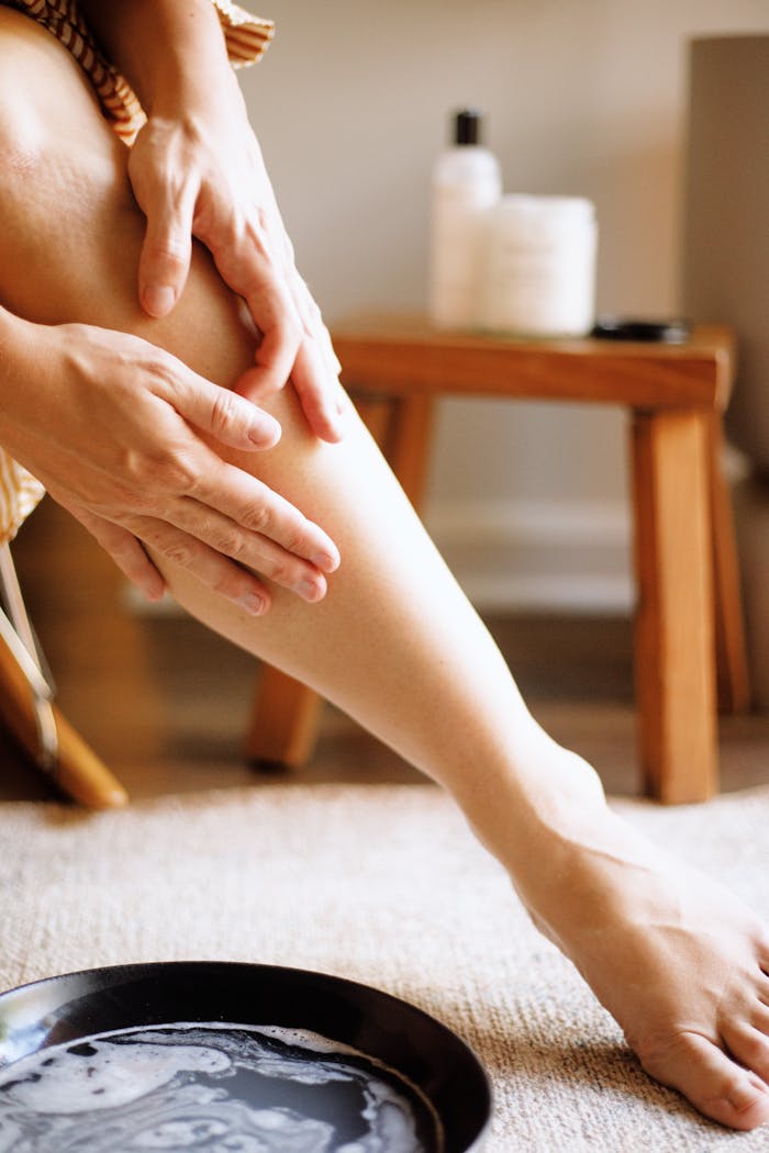 Woman applying natural skincare lotion in a cozy setting, highlighting gentle skin nourishment.
