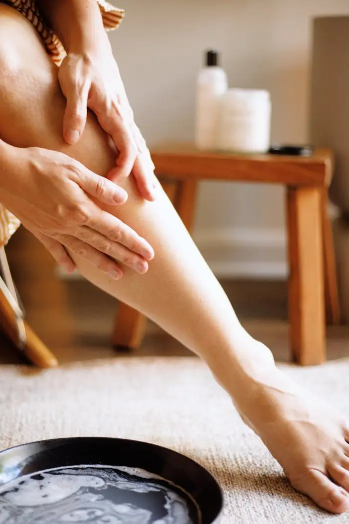 Woman applying natural skincare lotion in a cozy setting, highlighting gentle skin nourishment.